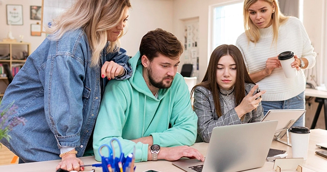 Zespół projektowy analizuje dostępność sklepu internetowego na laptopie i smartfonie, symbolizując wpływ WCAG 2.2 na branżę e-commerce.